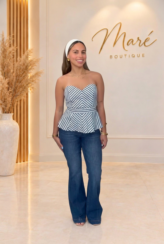 Modelo con top de rayas y mahón en el fondo de Maré Boutique